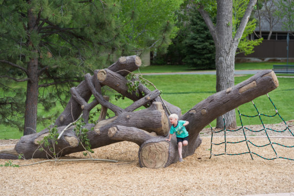 Boy playing on nature inspired ID Sculpture log climber